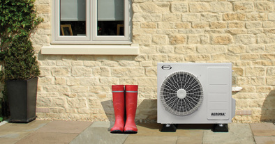 R32 heat pump next to red wellington boots